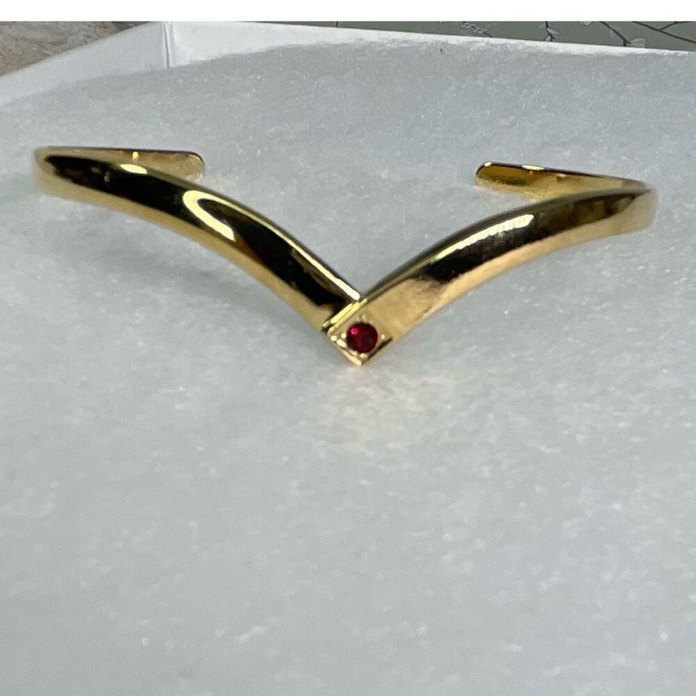 Avon gold tone V shaped cuff bracelet with faux ruby or garnet. Large